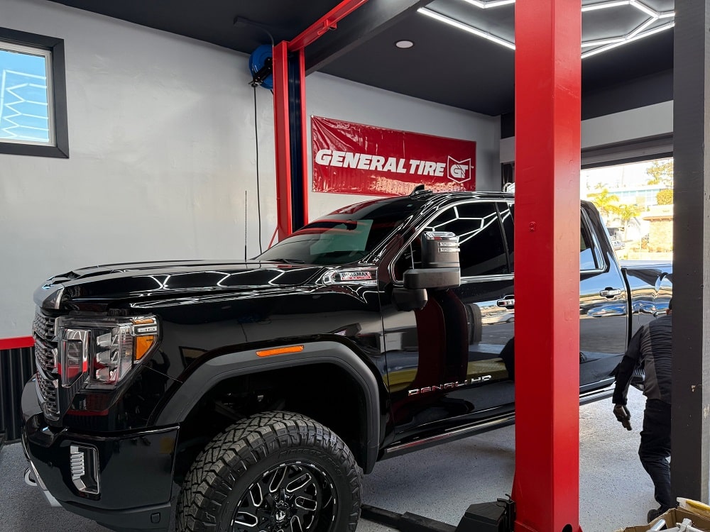 A GMC parked at an auto repair shop, awaiting car maintenance