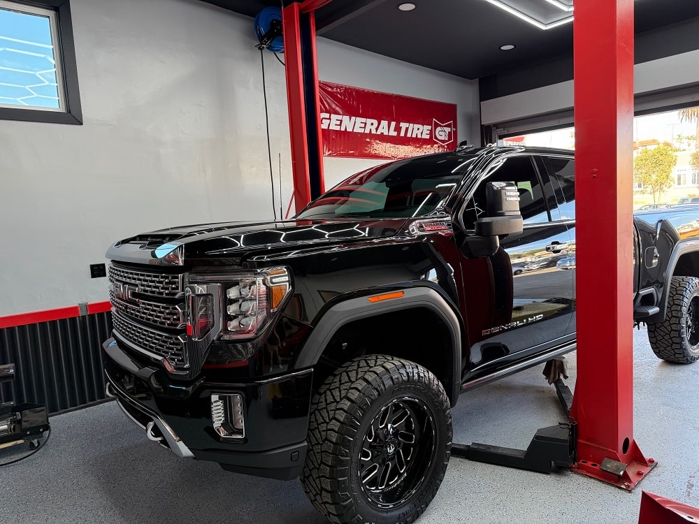 A GMC parked at an auto repair shop, awaiting car maintenance