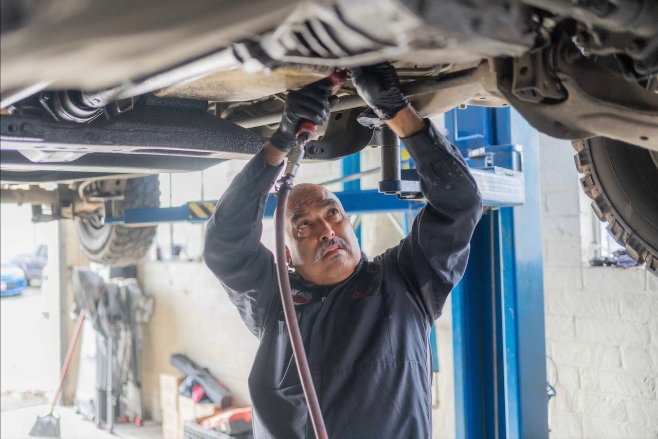 A skilled mechanic conducting repairs on car's undercarriage